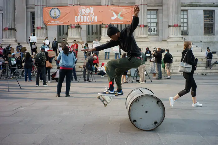 A photo of a skateboarder at Brooklyn Borough Hall during a demonstration.